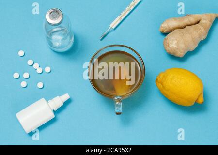 Vaporisateur nasal, pilules, bouteille de verre, thermomètre au mercure, tasse de thé, citron et gingembre. Vue de dessus. Concept de kit de traitement. Aliments de remède de santé pour c Banque D'Images