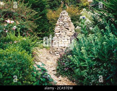 Un cairn en pierre de Cotswold est un beau point de discussion sur le jardin Banque D'Images