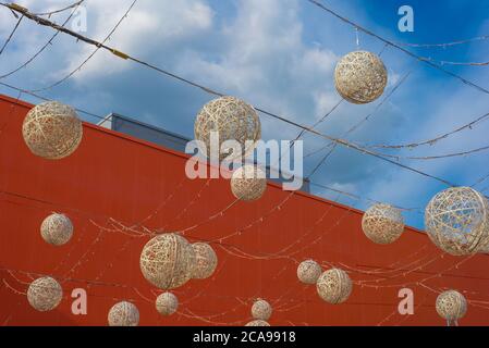 décoration de boules rondes de lampes, sur fond de ciel bleu avec nuages, sur fond d'une coupe de la construction d'une hyperma rouge Banque D'Images