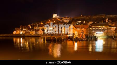 Vue nocturne sur la rivière Esk, East Cliff et la station de canot de sauvetage de Whitby, sur la côte du Yorkshire Banque D'Images