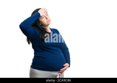 Femme enceinte ayant des maux de tête et touchant le front isolé sur fond blanc comme concept de grossesse de huit mois Banque D'Images