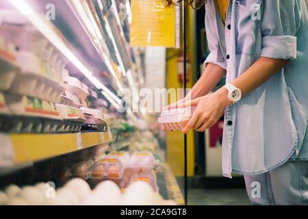 Une femme achète des œufs de poulet dans le magasin Banque D'Images