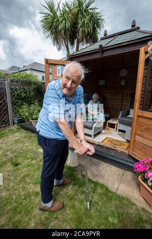 Couple de personnes âgées dans leurs années 80 appréciant le temps chaud d'été dans leur jardin d'été maison, Angleterre, Royaume-Uni Banque D'Images