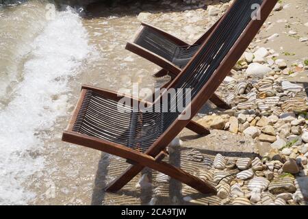 deux chaises longues en bois vides sur la mer de près Banque D'Images
