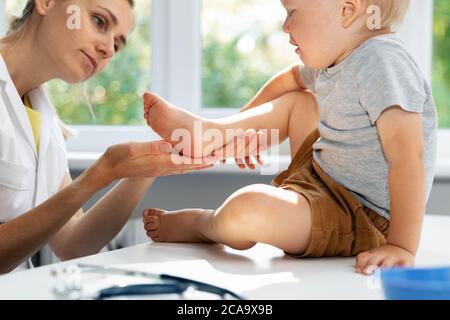 podiatre orthopédique vérifiant l'état des pieds des enfants dans le bureau de la clinique Banque D'Images