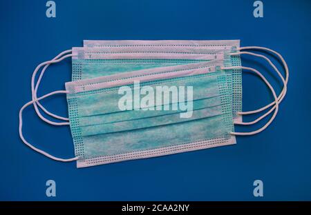 Masques médicaux verts de protection carbone activé fibre jetable face sur fond bleu. Masques pour le visage qui protège contre le virus, la grippe, le coronavirus. Banque D'Images