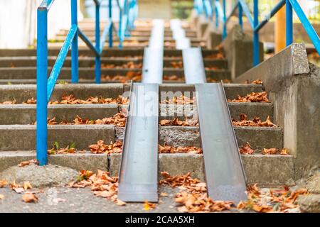 Marches avec rampe bleue, recouvertes de feuilles d'automne. Vue de dessous. Personne. Banque D'Images