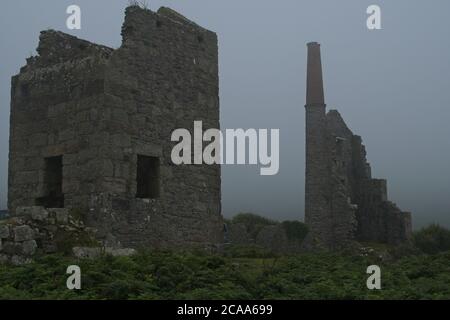 Ruines de Carn Galver Cornwall Mine d'étain en brume. Vestiges de bâtiments miniers et de travaux entourés par le format Paysage de brume Banque D'Images