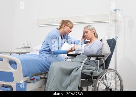 infirmière prendre le confort triste et pensive femme âgée isolée sur un fauteuil roulant près du lit dans la chambre d'hôpital, concept de la solitude et les maladies de vieillesse Banque D'Images