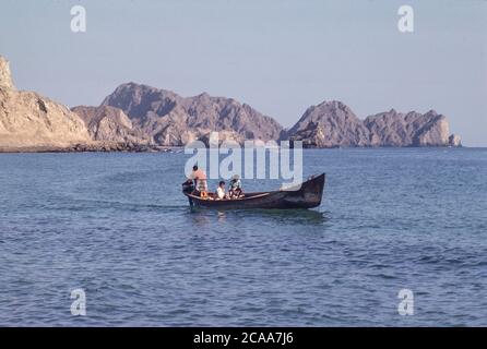 Archive image: Le Sultanat d'Oman en 1979, sept ans après le Sultan Qaboos a pris le pouvoir et a commencé à moderniser le pays. C'était encore une époque où le tourisme vers le pays en était à ses débuts. Image: Bateau de pêche traditionnel au large de Sidab avec promontoire rocheux à distance. Crédit: Malcolm Park Banque D'Images