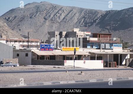 Archive image: Le Sultanat d'Oman en 1979, sept ans après le Sultan Qaboos a pris le pouvoir et a commencé à moderniser le pays. C'était encore une époque où le tourisme vers le pays en était à ses débuts. Image: Station-service, bâtiment moderne et montagne au soleil à distance, région de Ruwi. Crédit: Malcolm Park Banque D'Images