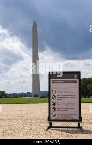 Washington D.C./USA- 4 août 2020: Une photo d'un panneau Covid 19 à D.C., avec le Washington Monument derrière lui. Banque D'Images