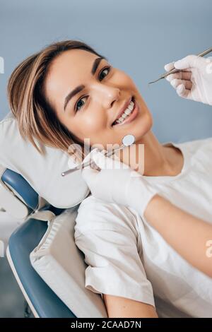 Un médecin dentiste professionnel examine et traite les dents abîmés à l'aide d'instruments dentaires spéciaux, d'équipements médicaux. Banque D'Images