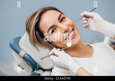 portrait de la jeune femme caucasienne avec un sourire parfait dans le cabinet dentaire, venez traiter les dents gâtées, regardez la caméra Banque D'Images