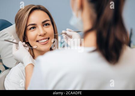 Un médecin dentiste professionnel examine et traite les dents abîmés à l'aide d'instruments dentaires spéciaux, d'équipements médicaux. Banque D'Images