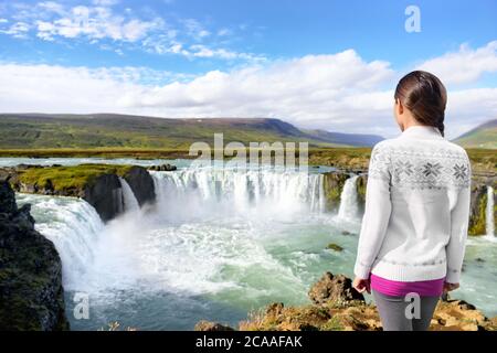 Voyages en Islande. Femme touristique par Godafoss cascade. Bonne jeune femme touristes appréciant paysage de la nature islandaise visite de touristes célèbres Banque D'Images