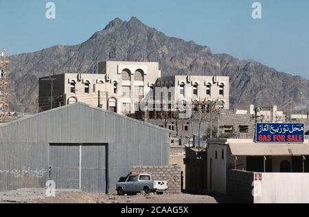 Archive image: Le Sultanat d'Oman en 1979, sept ans après le Sultan Qaboos a pris le pouvoir et a commencé à moderniser le pays. C'était encore une époque où le tourisme vers le pays en était à ses débuts. Image: Station-service, bâtiment moderne et montagne au soleil à distance, région de Ruwi. Crédit: Malcolm Park Banque D'Images