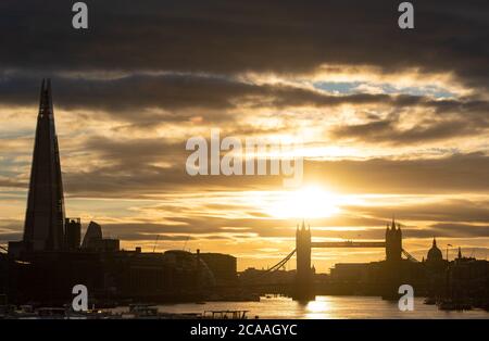 Le soleil se couche derrière les gratte-ciel de Londres, y compris (de gauche à droite) le Shard, le Tower Bridge et le dôme de la cathédrale Saint-Paul, tandis que le temps chaud continue. Banque D'Images