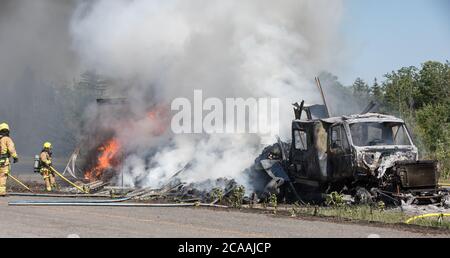 Un pompier vaporise de l'eau sur la remorque du tracteur. Banque D'Images