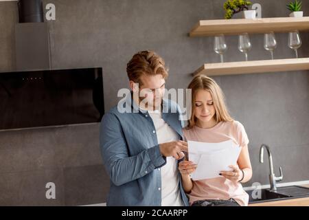 un gars intelligent aide sa fille à préparer un examen dans la salle de cuisine moderne. concept d'apprentissage, studing Banque D'Images