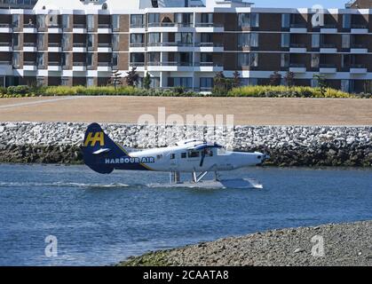 Victoria (Colombie-Britannique), Canada, 05 AOÛT 2020 - UN avion-taxi commercial de passagers de Harbour Air sort du port intérieur de Victoria et passe devant l'auberge de l'hôtel Laurel point en vue du décollage. Les compagnies aériennes de floatplane desservent à la fois les marchés locaux des transports de banlieue et les marchés touristiques. Don Denton/Alamy Live News Banque D'Images