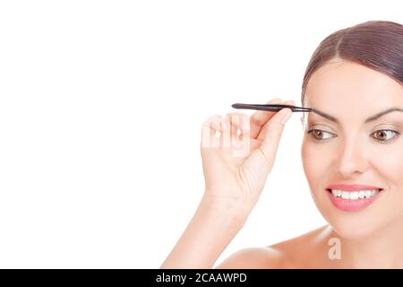 Jeune femme aux cheveux courts pleurs sourcils avec pinces gros plan, prise en studio. Sur fond blanc. Photo de beauté. Gros plan portrait, femme Pluckin Banque D'Images