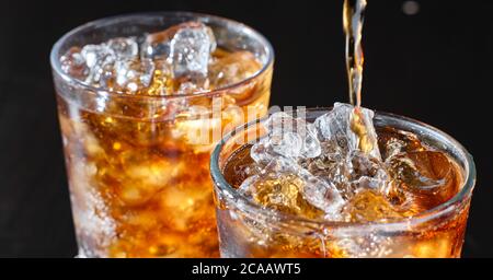 deux tasses de boisson gazeuse au cola sont versées dans le verre Banque D'Images