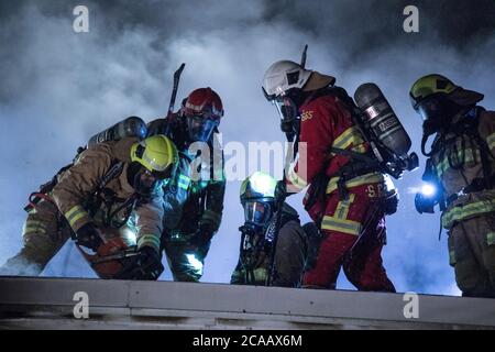 Les pompiers combattent le feu sur le toit. Banque D'Images