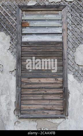 Vieux murs en bois avec plâtre base croisée avec fenêtre recouverte de planches. Anciennes structures de fenêtre en bois avec clous rouillés. Maison en bois mur vintage d Banque D'Images