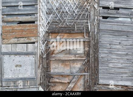 Vieux murs en bois avec plâtre base croisée avec fenêtre recouverte de planches. Anciennes structures de fenêtre en bois avec clous rouillés. Maison en bois mur vintage d Banque D'Images