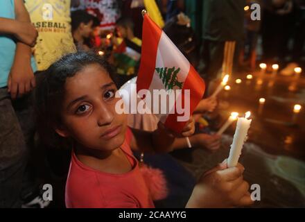 Gaza. 5 août 2020. Une fille palestinienne tient une bougie et un drapeau libanais pour manifester sa solidarité avec le peuple libanais dans la ville de Rafah, dans le sud de la bande de Gaza, le 5 août 2020. La Palestine a exprimé sa solidarité avec le Liban après les explosions massives qui ont secoué Beyrouth. Credit: Khaled Omar/Xinhua/Alamy Live News Banque D'Images