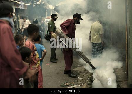 Des agents du bureau de santé local qui mènent une séance de formation de buée sur les insecticides, une prévention de l'éclosion de la dengue dans une région dense et peuplée de Jakarta. Banque D'Images