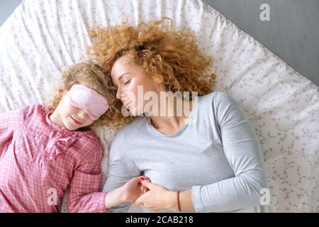 maman qui se repose et son enfant charmant. chambre double. famille qui a une bonne nuit de sommeil. vue de dessus. sommeil doux Banque D'Images