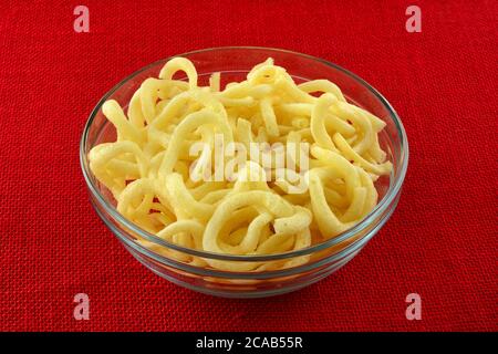 En-cas de rondelles d'oignon légèrement frites dans un bol en verre sur une nappe rouge Banque D'Images