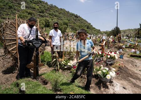 Chalco, Mexique. 05th Aug, 2020. Un jeune garçon de 10 ans travaille dans le cimetière pour créer des fondations de ciment pour les pierres tombales. Depuis le 1er mai, une nouvelle zone du cimetière a été ouverte pour faire place à des centaines de décès dus au coronavirus. Les creuseurs de tombes creusent généralement 2 ou 3 tombes par semaine mais jusqu'à récemment, ils creusaient 2 ou 3 tombes par jour. Environ 500 nouvelles tombes ont été creusées depuis le début du mois de mai. Credit: Lexie Harrison-Cripps/Alamy Live News Banque D'Images