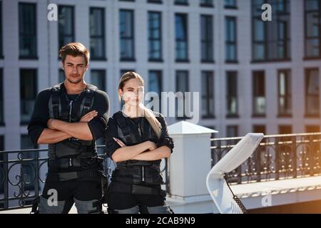 Jeunes ambitieux, en costume électrique musculaire, debout près de la machine EMS. gros plan photo. Espace de copie Banque D'Images