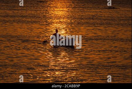 Srinagar, Cachemire sous contrôle indien. 5 août 2020. Un boatman délague son bateau au coucher du soleil sur le lac Dal, dans la ville de Srinagar, la capitale estivale du Cachemire sous contrôle indien, le 5 août 2020. Crédit : Javed Dar/Xinhua/Alay Live News Banque D'Images