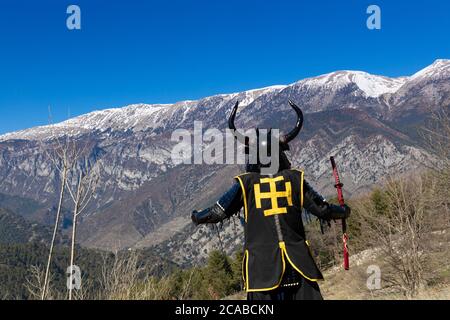 Guerrier japonais Samurai vêtu d'une armure avec une montagne hypnotisante arrière-plan Banque D'Images