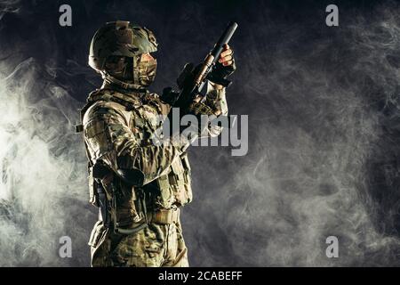 attaque pendant la guerre. homme effectuant un service militaire visant son fusil d'arme côté, allant à l'attaque Banque D'Images