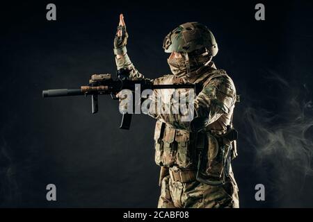 portrait d'un adulte effectuant un service militaire, soldat avec fusil, homme intrépide en tenue militaire Banque D'Images