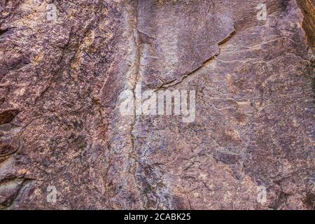 Gros plan des fissures sombres de la falaise de la rade. Texture roche en pierre grise des montagnes. Concept de géologie et d'alpinisme Banque D'Images