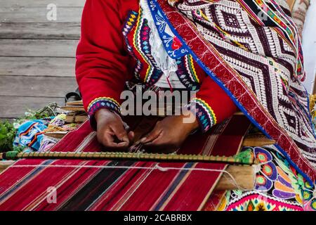 Photo en grand angle d'une femme en couture de vêtements traditionnels sous la lumière du soleil Banque D'Images