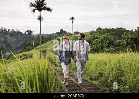 Asie, Indonésie, Bali, jeune couple caucasien, portant des vêtements élégants et décontractés, profitant d'une promenade le long de la célèbre crête de Campuan, l'un des plus connus de Banque D'Images