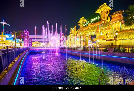 DUBAÏ, Émirats Arabes Unis - 5 MARS 2020 : admirez les fontaines colorées sur le canal de Global Village avec une vue sur le pavillon de la Chine et la grande roue dans luna Park à l'arrière Banque D'Images