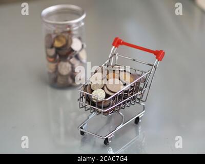 Mini modèle de chariot type dans le supermarché et beaucoup de pièces se trouvent dans des boîtes en plastique transparent hors de l'arrière-plan Banque D'Images