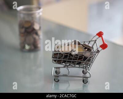 Mini modèle de chariot type dans le supermarché et beaucoup de pièces se trouvent dans des boîtes en plastique transparent hors de l'arrière-plan Banque D'Images