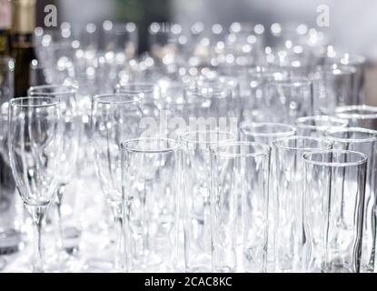 Beaucoup de différents verres vides sur la table. Préparation pour un banquet, des vacances ou un mariage. Arrière-plan flou. Banque D'Images
