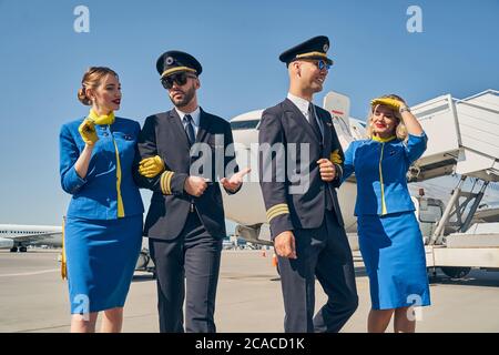 Jeune équipage de cabine caucasien vêtu d'uniformes élégants Banque D'Images