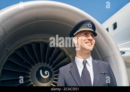 Sourire ravie aviateur en uniforme regardant vers le haut Banque D'Images