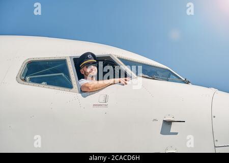 Jeune aviateur en lunettes de soleil posant pour la caméra Banque D'Images